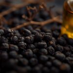 Schwarze Pfefferkörner und Wacholderbeeren mit ätherischem Öl – Symbolbild für das Terpen Sabinen